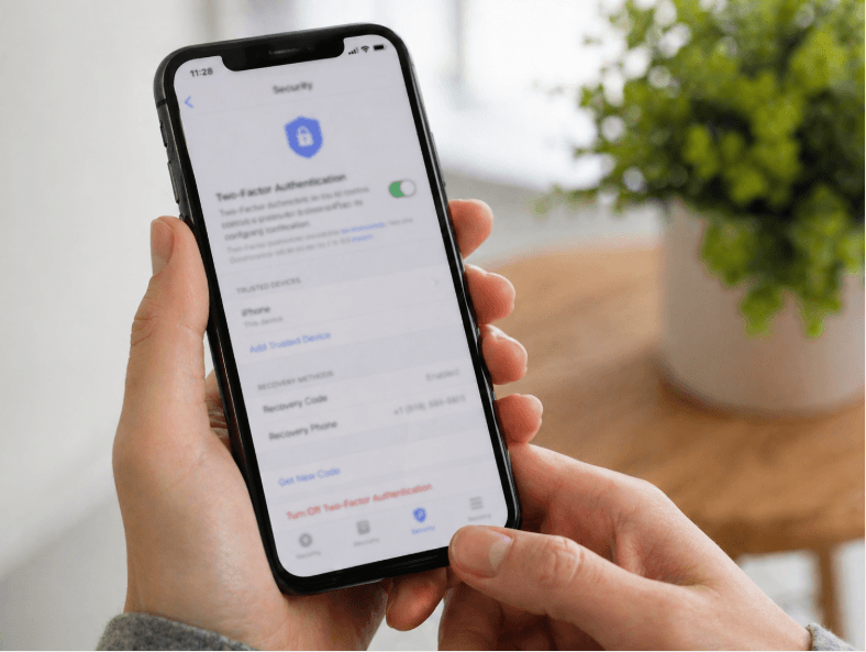 person holding a smartphone with two-factor authentication security settings turned on