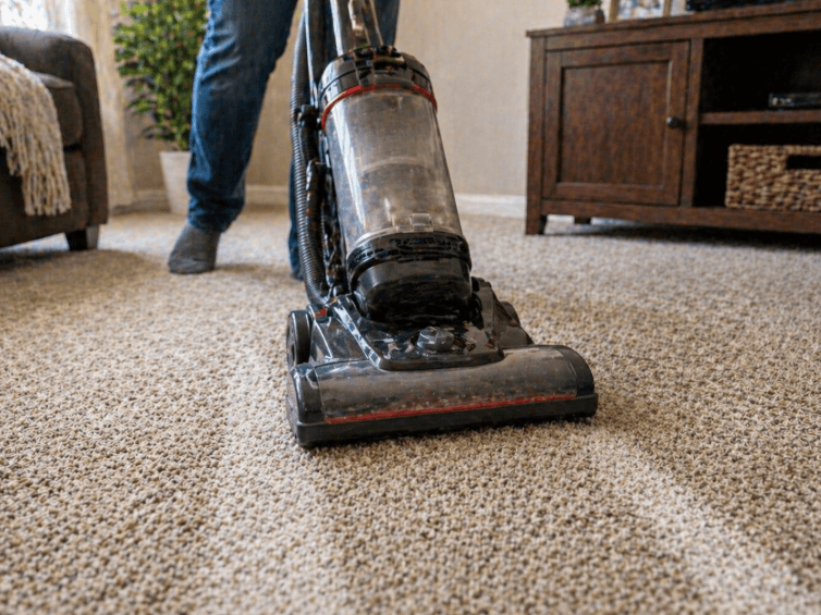vacuum cleaner removing baking soda and dirt from carpet in a living room